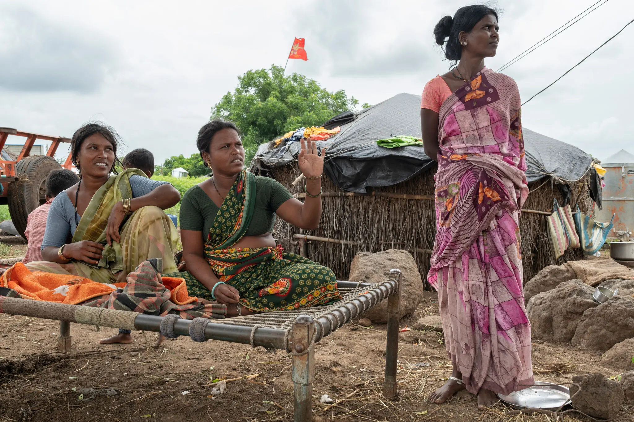 Pushpa Pawar, 31, standing with relatives in the village of Kolgaon, India. Ms. Pawar’s husband, Prahlad Pawar, a cane cutter, said that the couple and their children had been detained by a contractor and forced to work as servants.Credit...Saumya Khandelwal for The New York Times