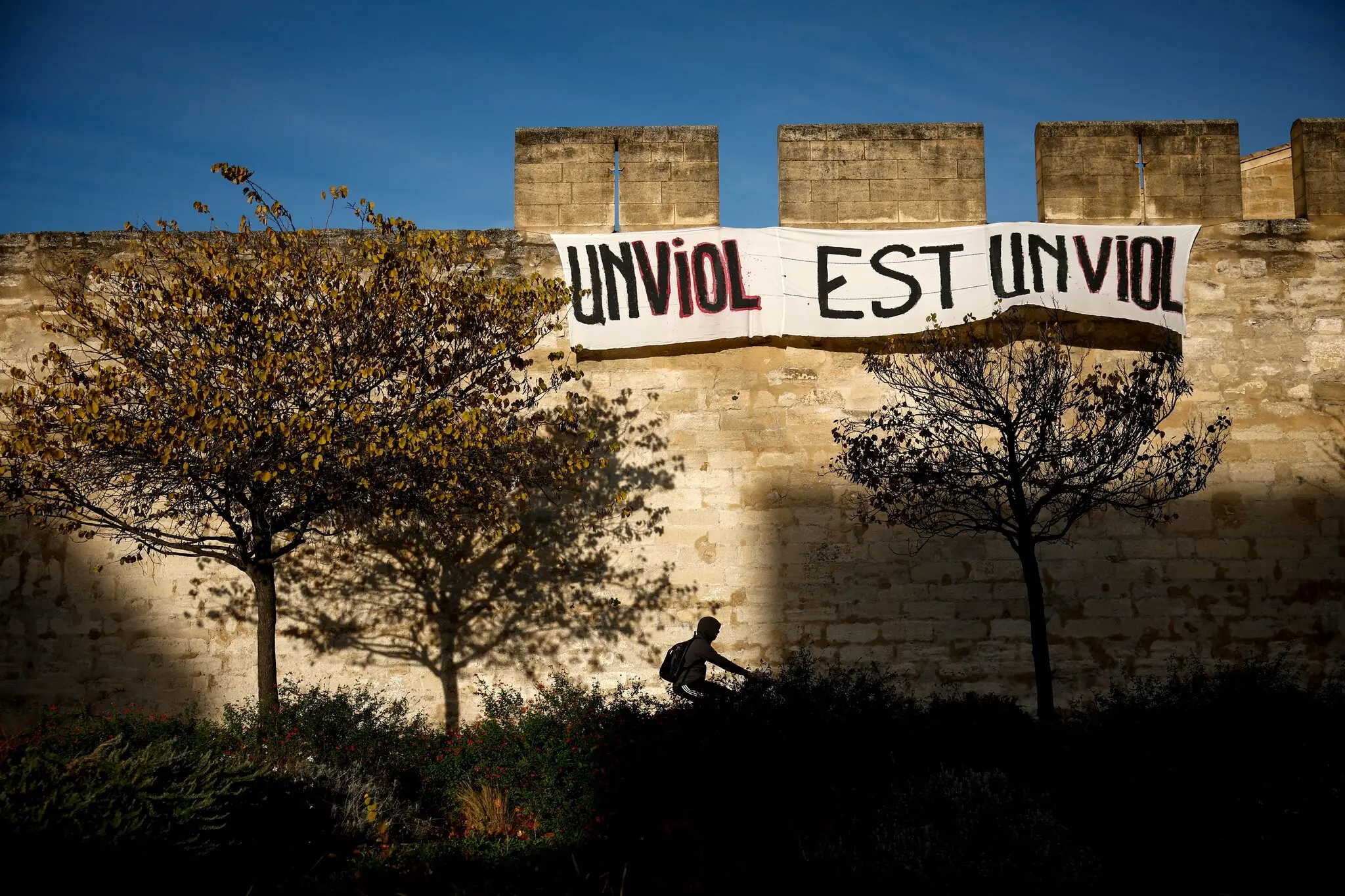 The walls of Avignon, France, draped with a banner in French meaning “Rape is rape.” The Pelicot trial was occurring in the modern courthouse just across the road.Credit...Yoan Valat/EPA, via Shutterstock