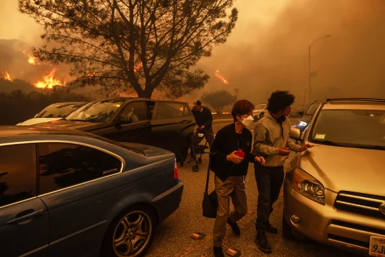 People flee the advancing Palisades Fire by car and on foot in Pacific Palisades, Calif., on Tuesday.Etienne Laurent / AP