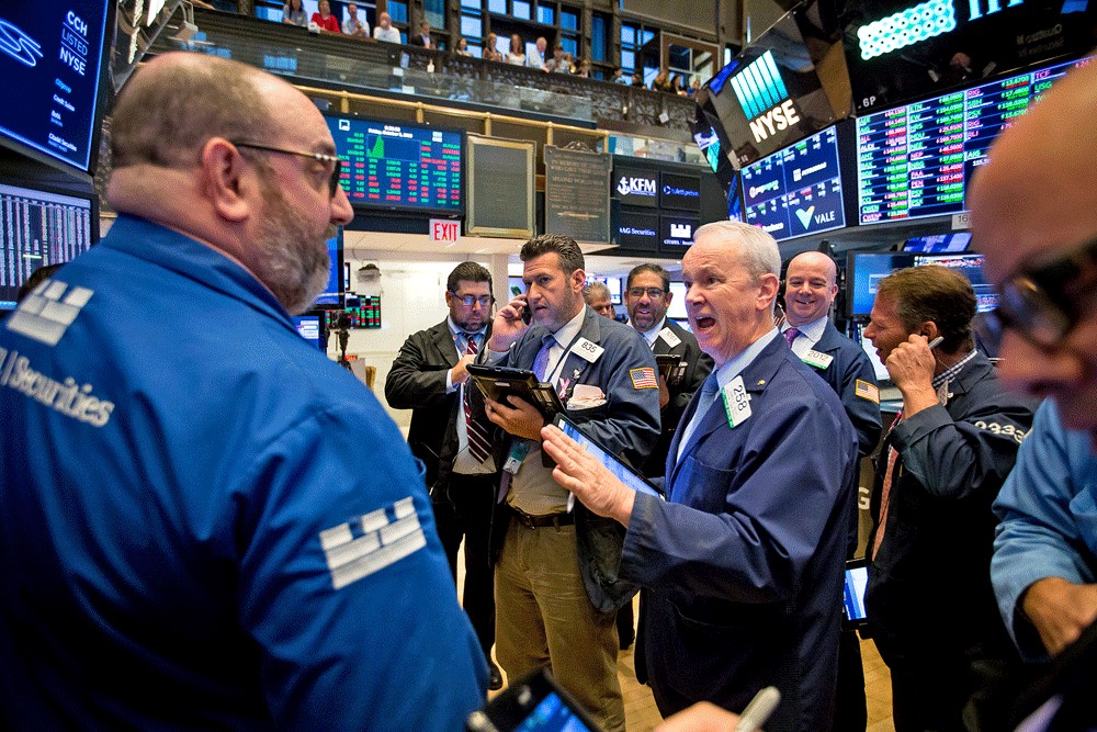 Traders work on the floor of the New York Stock Exchange in New York, the United States. The New York Stock Exchange will temporarily shut its trading floors starting Monday and move to fully electronic trading after an employee and a person who worked on the floor both tested positive for coronavirus this week. (Bloomberg/Michael Nagle)