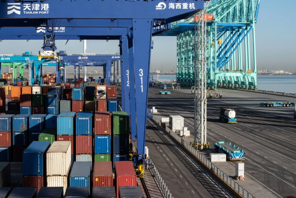 Autonomous vehicles transport shipping containers at Tianjin port.Source: Bloomberg