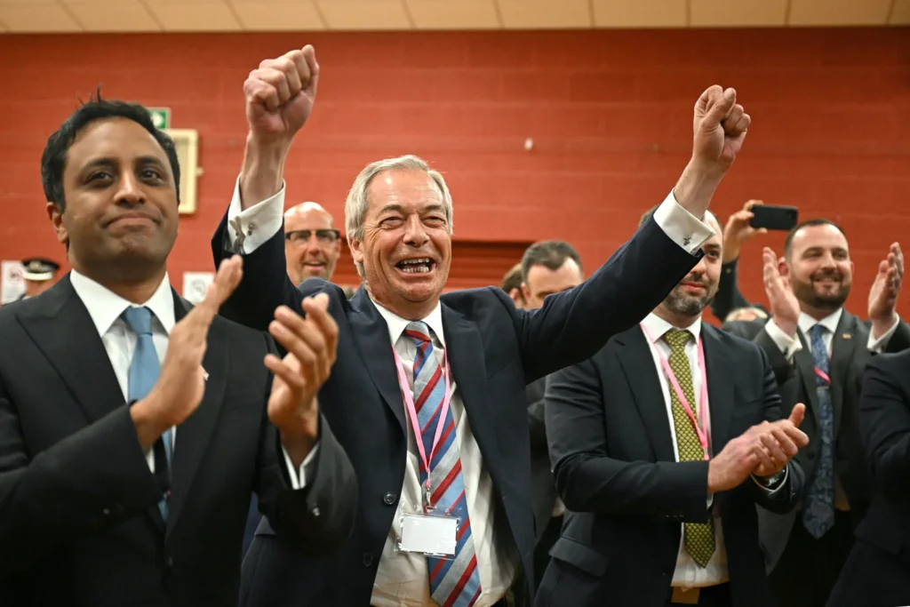 Nigel Farage, leader of the Reform U.K. party, center, celebrating in the early hours of Friday. (Oli Scarff/Agence France-Presse/Getty Images)
