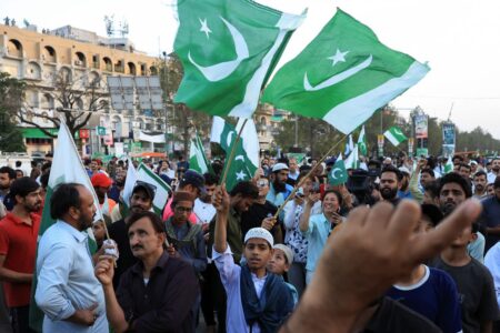 People wave Pakistani flags in celebration after the ceasefire announcement with India, in Islamabad, Pakistan, on Saturday. (Akhtar Soomro/Reuters)