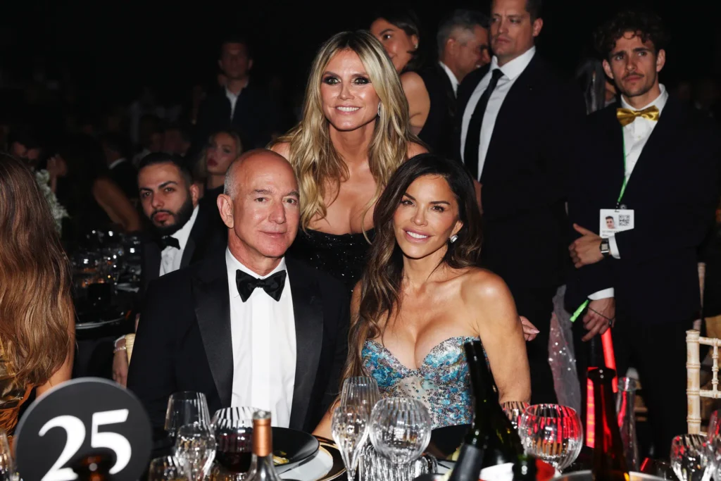 From left, Jeff Bezos, Heidi Klum and Lauren Sánchez inside the amfAR gala on Thursday. (Pascal Le Segretain/amfAR/Getty Images)