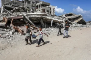 Young Palestinians pass destroyed buildings Monday in Khan Younis, Gaza. (Abed Rahim Khatib / Anadolu/Getty Images)