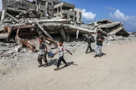 Young Palestinians pass destroyed buildings Monday in Khan Younis, Gaza. (Abed Rahim Khatib / Anadolu/Getty Images)