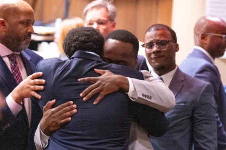 Former Memphis Police Department officers Demetrius Haley, left, and Tadarrius Bean, center, hug Wednesday in Memphis as Justin Smith Jr., right, becomes emotional after they were acquitted of state charges. (Chris Day/Memphis Commercial Appeal/USA Today Network/Pool/AP)