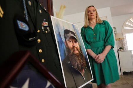 Stacey Wales, 47, stands next to a photo of her brother, Chris Pelkey, who died in a road rage shooting in 2021, in Chandler, Arizona, U.S., May 8, 2025. (REUTERS/Liliana Salgado)