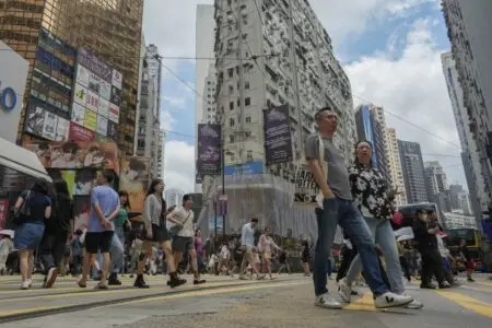 Pedestrians cross the road in Causeway Bay. A Hong Kong property investor has been divesting assets despite a downturn in the property market. (Sun Yeung)