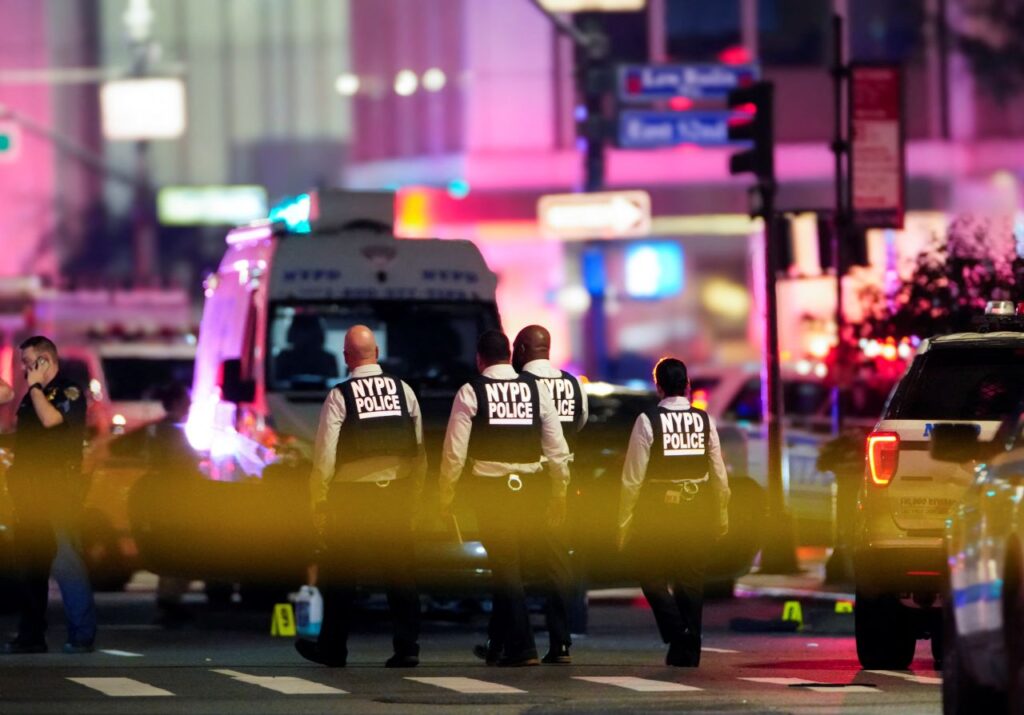 NYPD officers work near the scene of the shooting in Manhattan on Monday. © Eduardo Munoz/Reuters