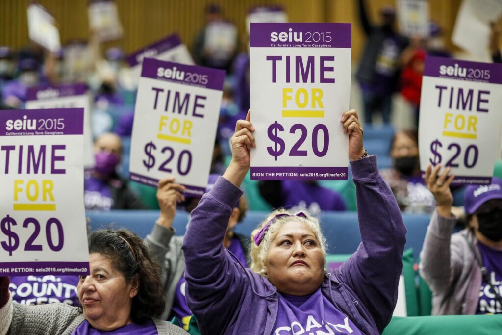 Workers advocate for a $20 minimum wage during a protest at the Kenneth Hahn Hall of Administration in Los Angeles on Nov. 1, 2022. © Los Angeles Times/Getty Images