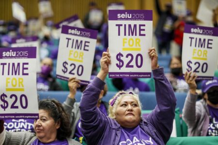 Workers advocate for a $20 minimum wage during a protest at the Kenneth Hahn Hall of Administration in Los Angeles on Nov. 1, 2022. © Los Angeles Times/Getty Images