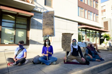 Protesters sit across the street from the U.S. Immigration and Customs Enforcement building in Portland, Oregon, on Saturday. © Mathieu Lewis-Rolland/Getty Images