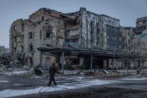 A man walks down a war-ravaged street in Pokrovsk, an industrial city in eastern Ukraine's Donetsk region, on Dec. 19, 2024. Behind him is the hotel Druzhba, which was destroyed by a Russian missile last summer. Pokrovsk was once home to 60,000 people. Now it's largely abandoned, with Russian troops active within a mile of the outskirts. © Anton Shtuka/NPR
